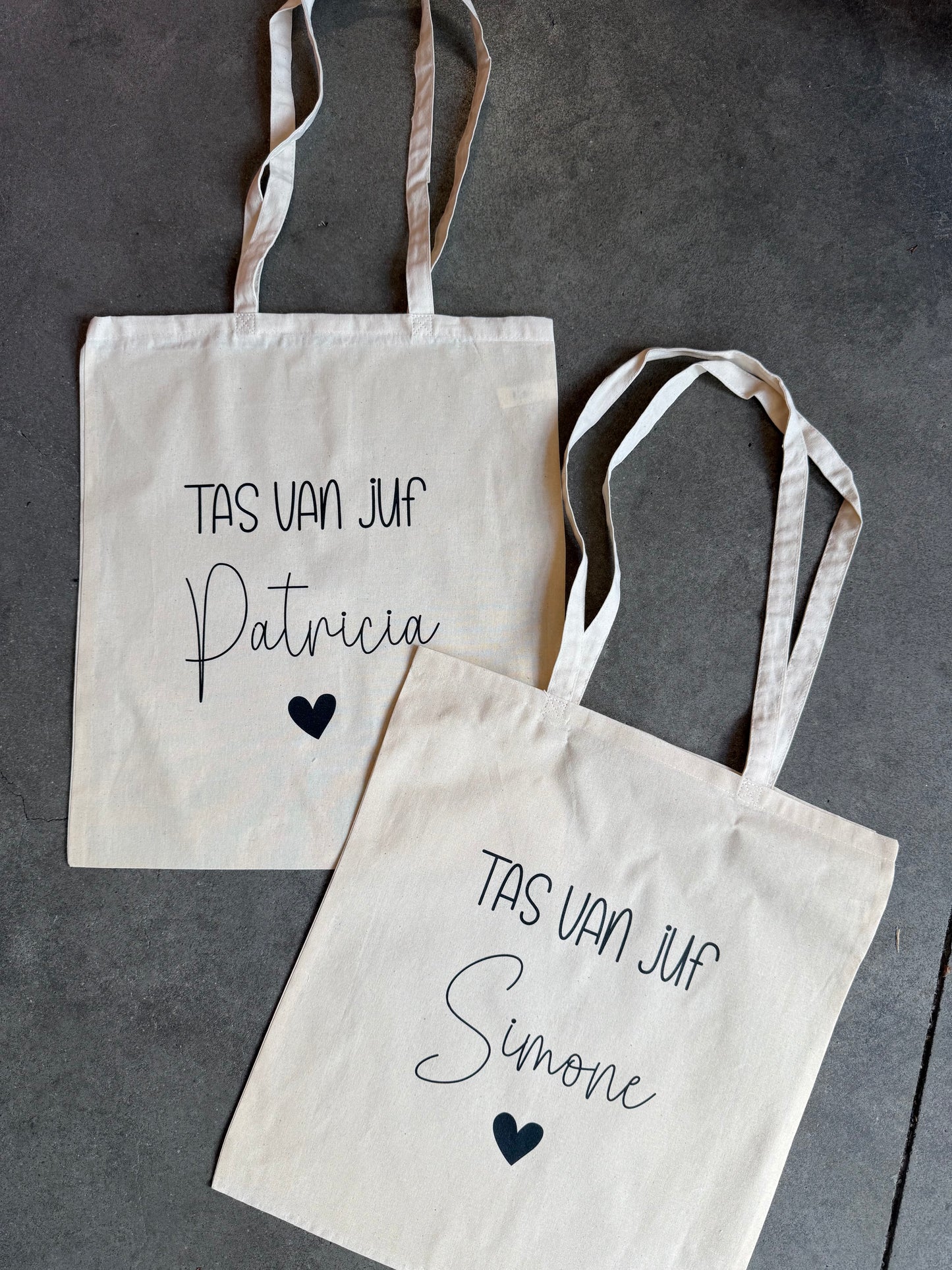 Twee tote bags met de tekst tas van juf Patrica en de andere met Sandra met een hartje eronder