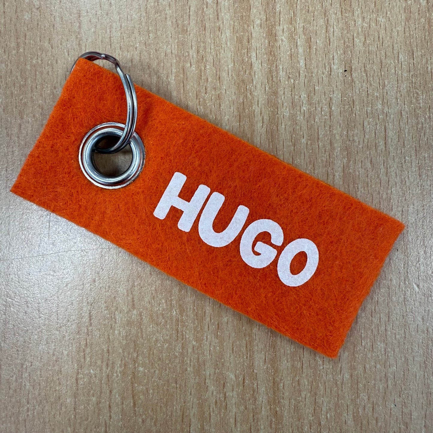 Oranje vilten sleutelhanger met de naam Hugo
