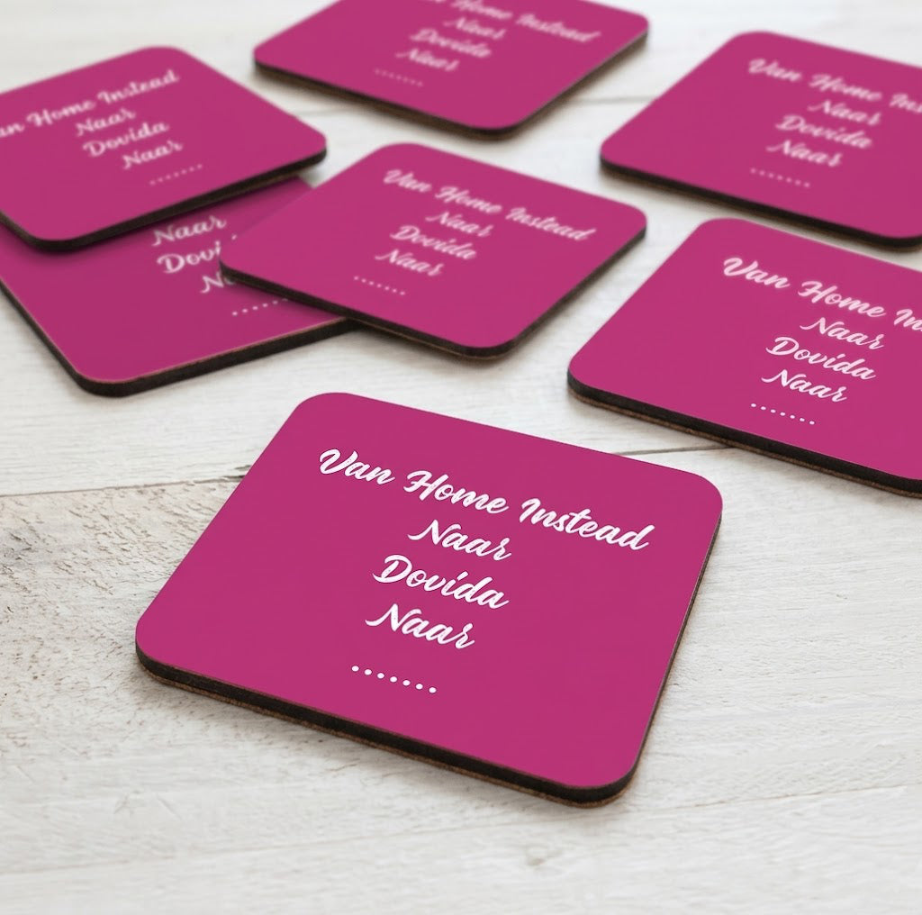 Voorbeeld van een set van 6 gepersonaliseerde roze onderzetters met eigen tekst en ontwerp op een houten tafel