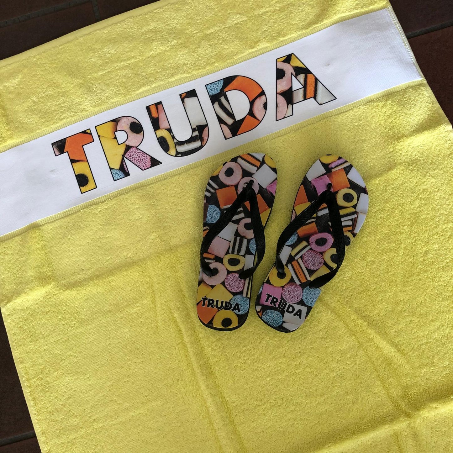 Slippers en badlaken bedrukt met engelse drop en de naam truda