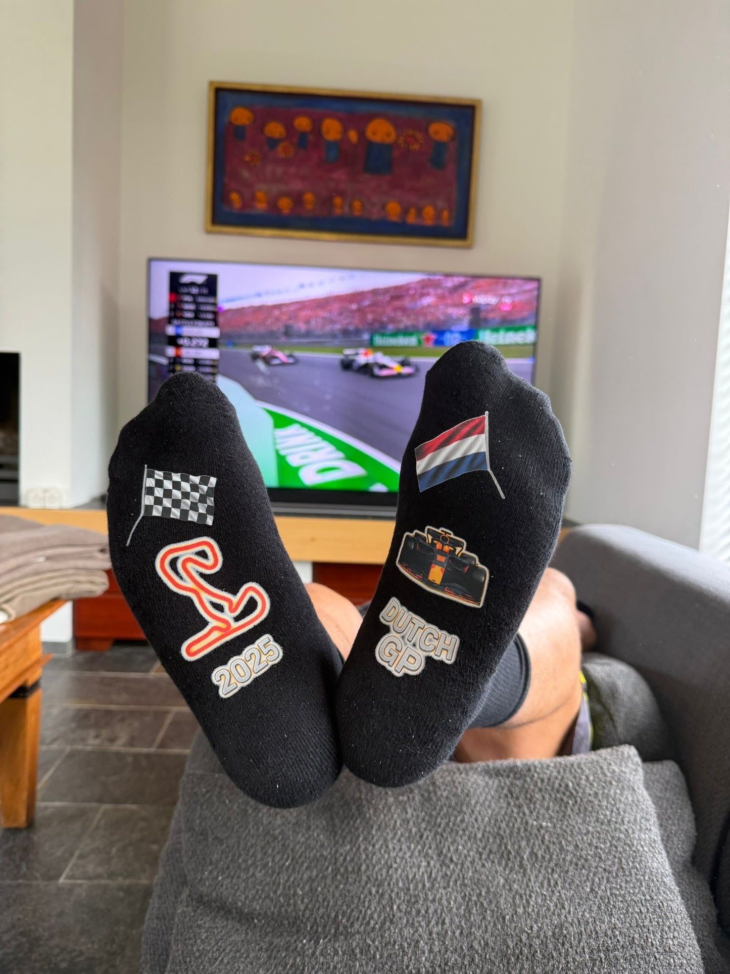 Limited edition Formule 1 sokken Dutch GP Zandvoort 2025. Met op de achtergrond de wedstrijd live op TV.