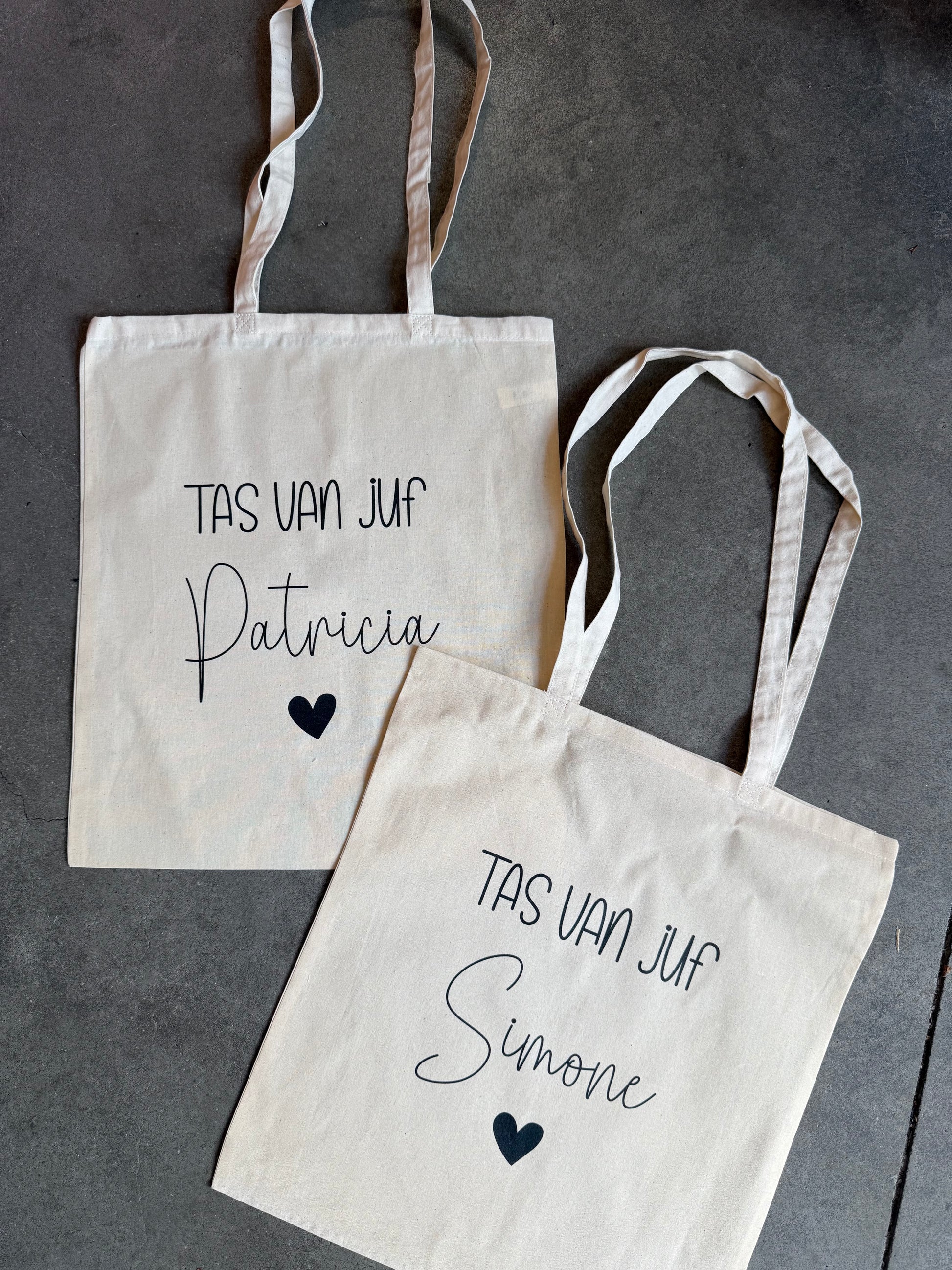 Twee tote bags met de tekst tas van juf Patrica en de andere met Sandra met een hartje eronder