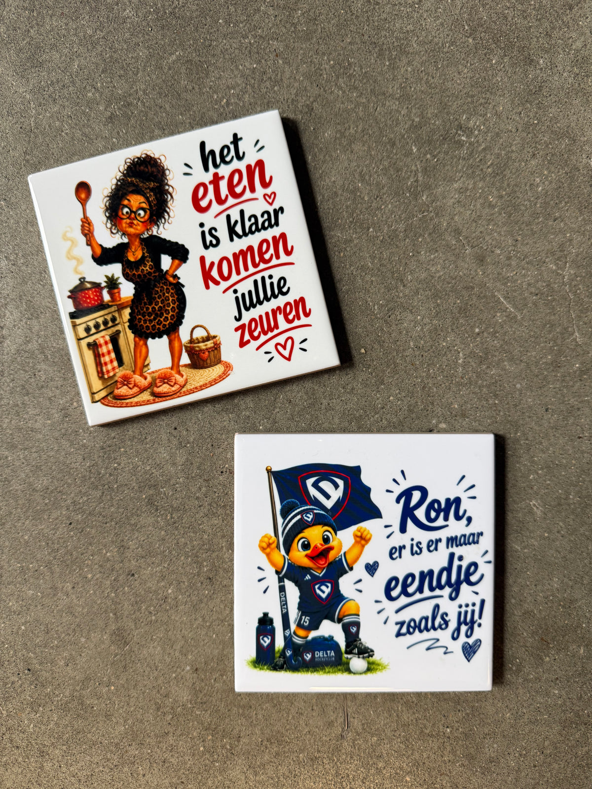 Twee tegeltjes bedrukt met eigen ontwerp. Een voor hockeyclub Delta en een voor een moeder in de keuken.