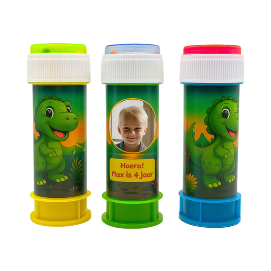 Drie bellenblaaspotjes met dino-thema, kleurrijke wikkel met cartoon-dinosaurussen. Middenpotje met foto van jongen en tekst “Hoera! Max is 4 jaar”.
