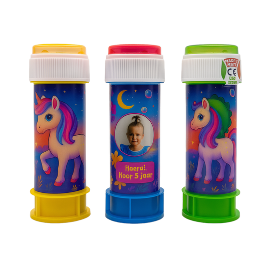 Drie bellenblaaspotjes met eenhoorn-thema, kleurrijke wikkel in magische stijl. Middenpotje toont een foto van een meisje met de tekst “Hoera! Noor 5 jaar”.

