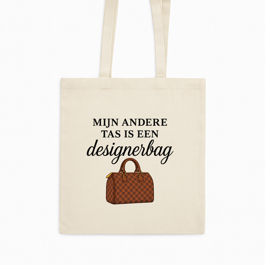 Tote bag met de tekst “Mijn andere tas is een designerbag” en illustratie van een bruine designerhandtas