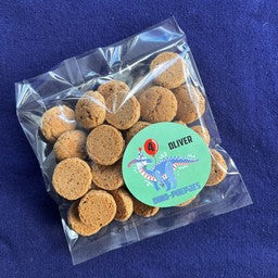 Detailfoto dino poepies traktatie: ronde sticker met een dino met ballon, naam en leeftijd op zakje kruidnoten