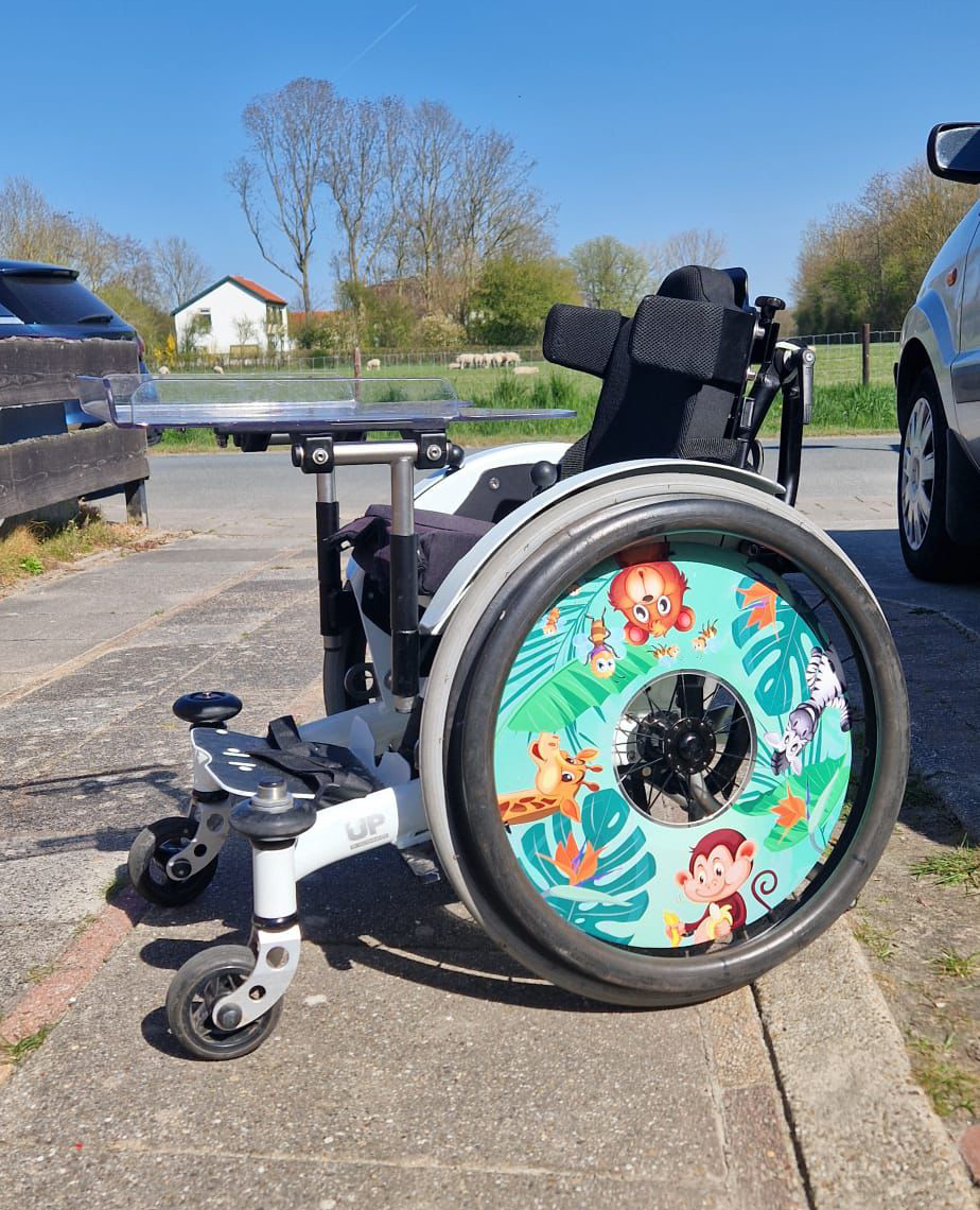 Rolstoel met jungle-dieren stickers op de spaakbeschermers