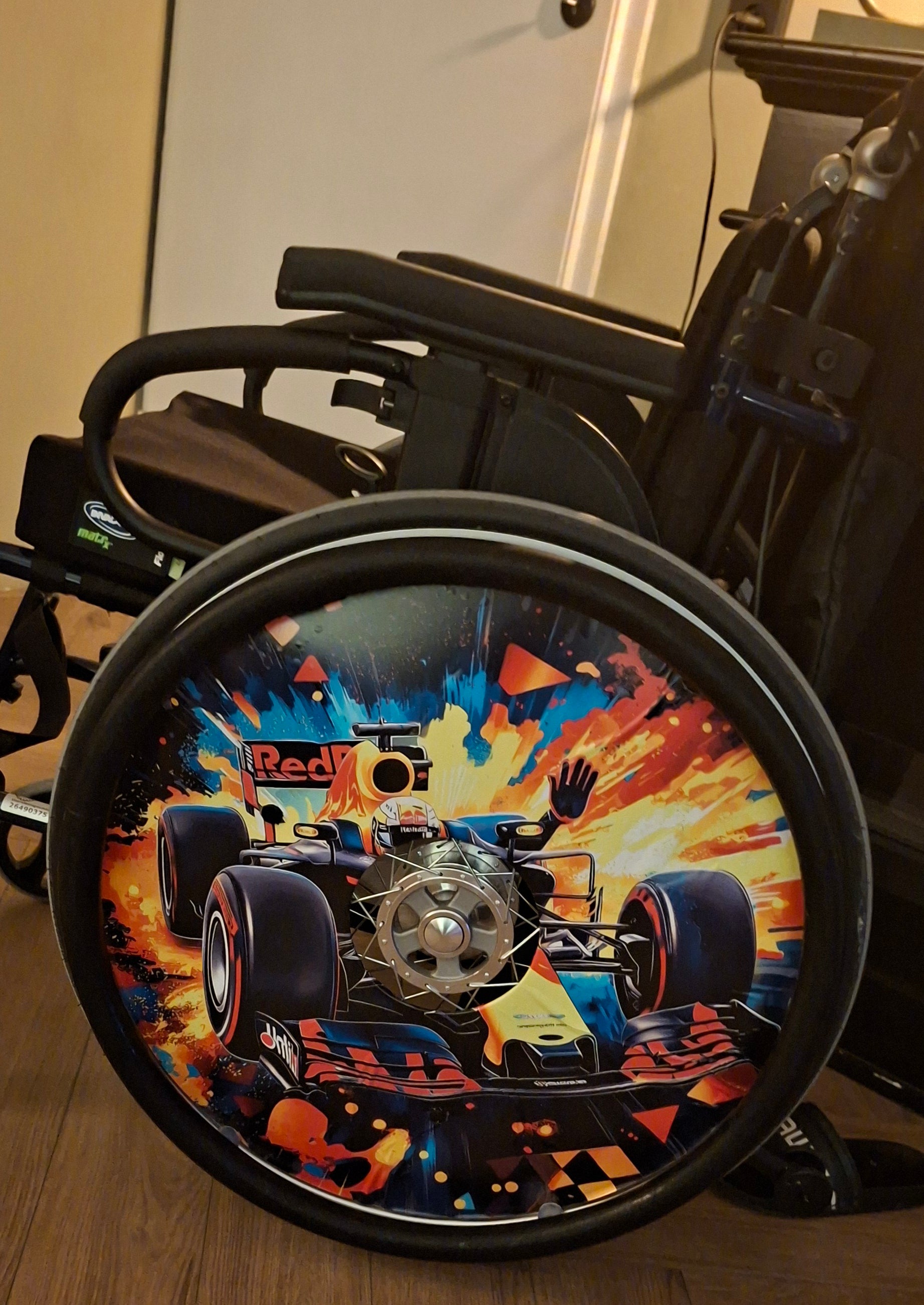 rolstoel met formule 1 sticker van traktatiecorner op de spaakbeschermers