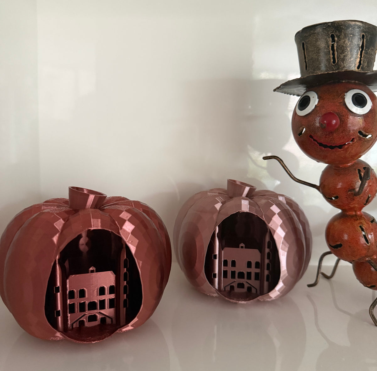 Twee pompoenen met stadhuis Venlo, in koper en rose kleur